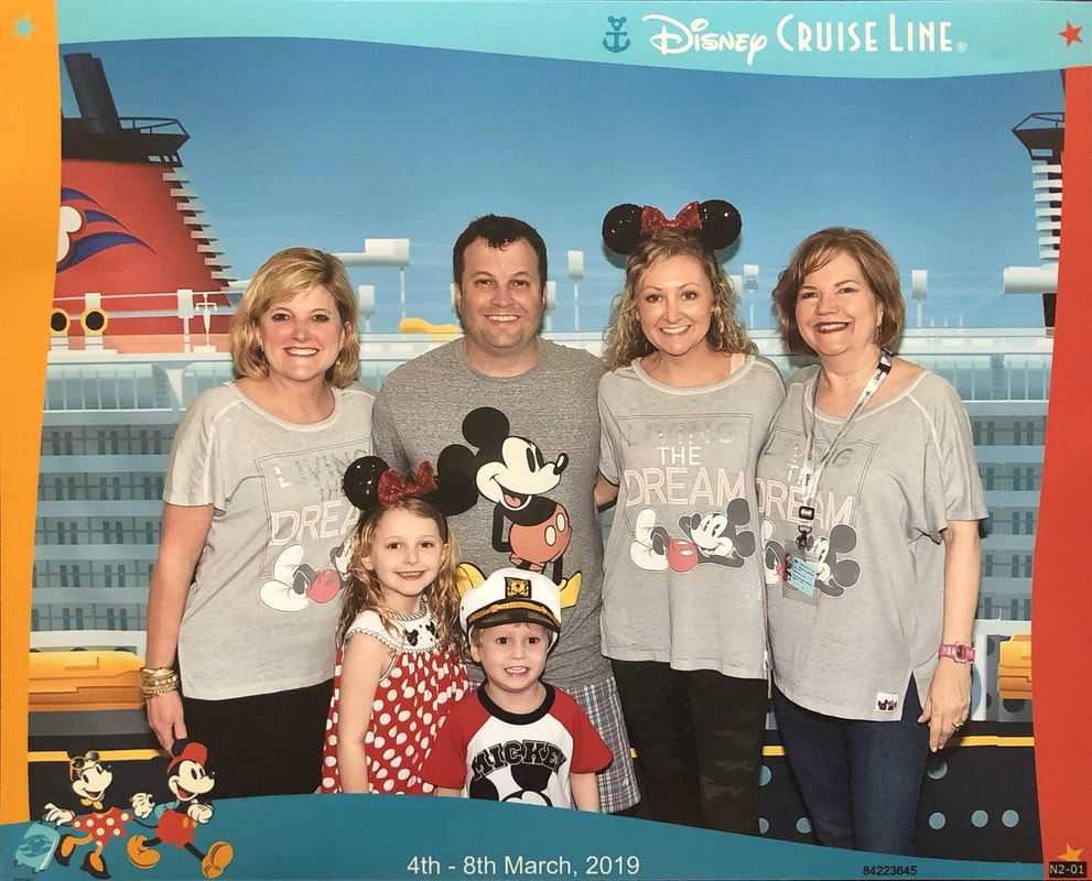 Group picture of 4 adults,  2 kids in Disney shirts right before boarding Disney Cruise